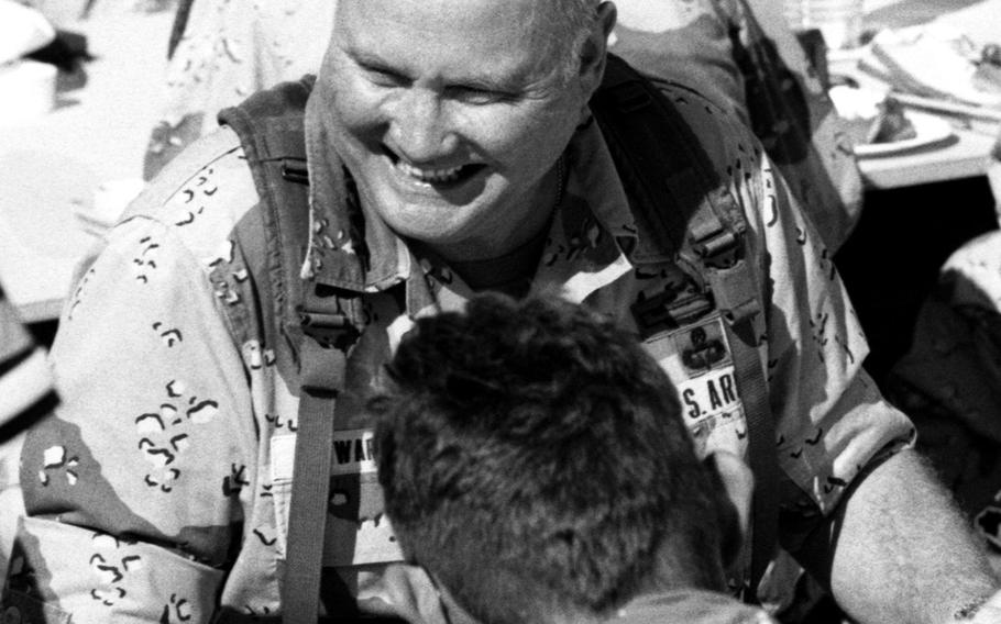 Gen. Norman Schwarzkopf enjoys Thanksgiving dinner with American servicemembers at a base in the Saudi Arabian desert during Operation Desert Shield in November, 1990.