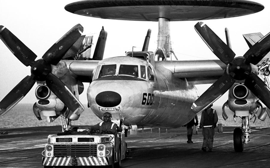 An E-2C Hawkeye early warning aircraft is towed along the flight deck of the USS Saratoga in the Red Sea during Operation Desert Shieldin November, 1990. The Hawkeye, with its large radar dome, was said to be capable of monitoring any flight activity within 500 miles of the carrier.