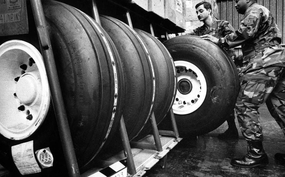 At Rhein-Main Air Base in November, 1990, Senior Master Sgt. James Harper, satellite chief of supply, and Tech. Sgt. Wilford Raiford, superintendent of the forward supply location, do a spot check of a war readiness kit pallet, examining a 300-lb. main gear tire for a C-141.