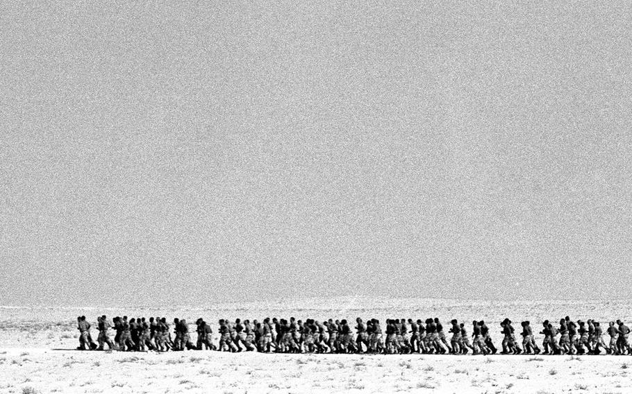 Soldiers from the 24th Infantry Div. (Mech.) march across the Saudi Arabian desert during Operation Desert Shield in October, 1990. One soldier checked off the realities of life on the sand: "No base camp. No PX. No females." And if that weren't enough, a fire at a division postal tent destroyed a good portion of the troops' mail.