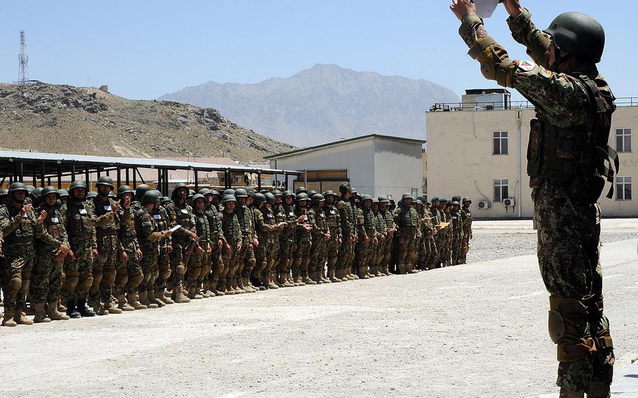 A member of the Afghan National Engineer Brigade proudly displays his certificate of training to fellow brigade members at a graduation ceremony June 18, 2014.