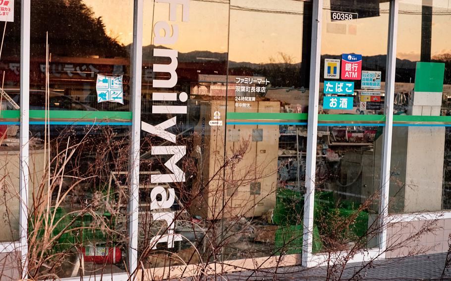 Stock can be seen through the windows of an abandoned convenience store along the highway in Futaba, Japan, Feb. 10, 2016. The store has remained vacant since the city was evacuated five years ago.