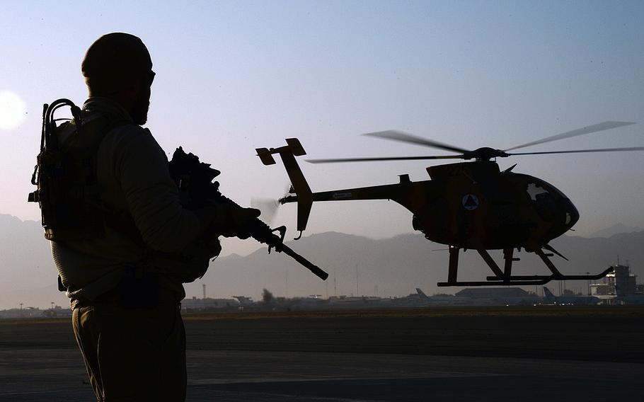 A U.S. soldier provides security while an MD-530 Cayuse Warrior takes off with an all-Afghan crew for a combat mission on Sept. 27, 2015.