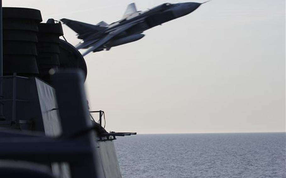 In this image released by the U.S. Navy, a Russian SU-24 jet makes a close-range and low altitude pass near the USS Donald Cook on Tuesday, April 12, 2016, in the Baltic Sea. The Russian attack planes buzzed the U.S. Navy destroyer multiple times on Monday and Tuesday, at one point coming so close, an estimated 30 feet, that they created wakes in the water around the ship, a U.S. official said on Wednesday. 