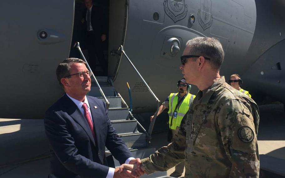 Secretary of Defense Ash Carter is greeted by Lt. Gen. Sean MacFarland as he arrives in Baghdad, Monday, April 18, 2016. Carter is there to discuss the possibility of sending additional U.S. troops and other support to Iraq as its army begins the fight for Mosul. 