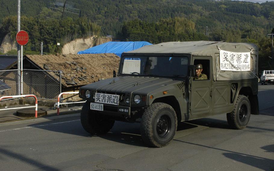 A Japanese Self Defense Force vehicle drives past earthquake-damaged houses near Kumamoto, Japan, on Tuesday, April 19, 2016. Thousands of Japanese people have been sleeping in the streets since two earthquakes hit the region last week. 


