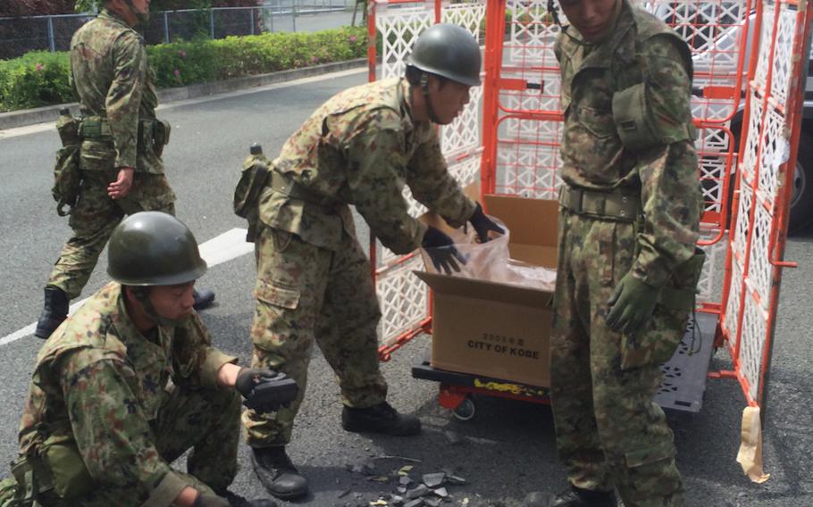Japan Self Defense Force soldiers clear earthquake debris from a carpark beside Kumamoto Castle April 20, 2016. 