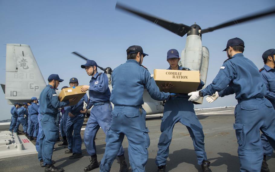 U.S. Marines assigned to the 31st Marine Expeditionary Unit and Japan Self Defense Force members transport supplies onto an MV-22B Osprey aboard the Japanese destoyer JS Hyuga, April 19, 2016. The supplies are in support of the relief effort after a series of earthquakes struck the island of Kyushu. 