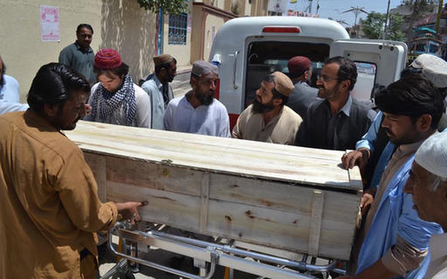 People stand near a coffin carrying a body one of the victims in a reportedly U.S. drone strike in the Ahmad Wal area in Baluchistan province of Pakistan, at a local hospital in Quetta, Pakistan, Sunday, May 22, 2016. A senior commander of the Afghan Taliban confirmed on Sunday that the extremist group's leader, Mullah Mohammad Akhtar Mansour, has been killed in the strike.