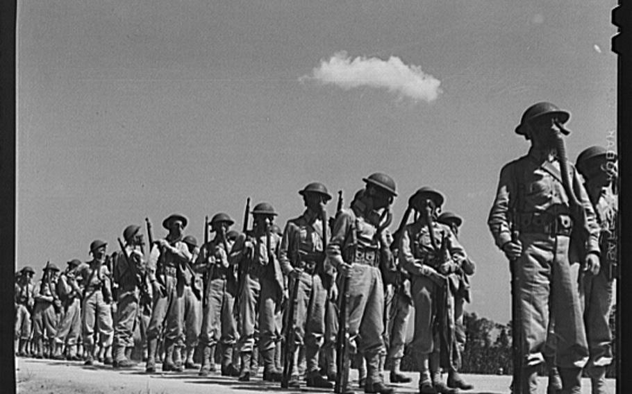 Soldiers wearing gas masks after having been sprayed with gas from a plane at Edgewood Arsenal, Md., in June 1942.