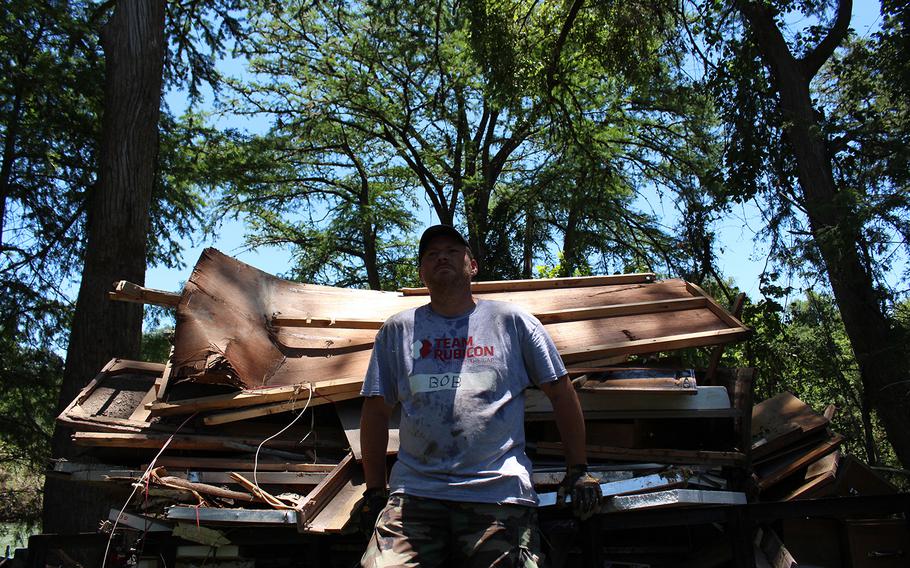 A volunteer with Team Rubicon rests following collection of debris following recent flooding in Bandera, Texas, on June 6, 2016.