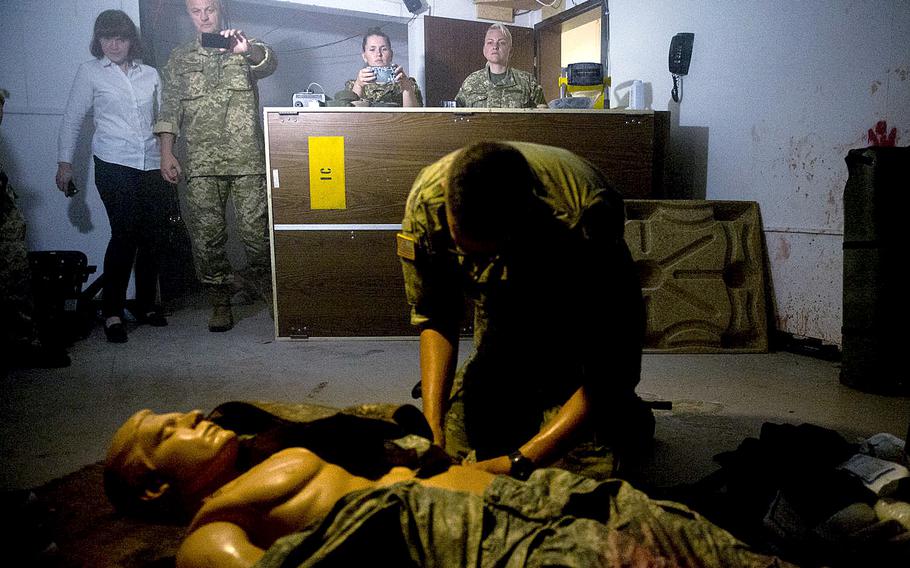 Ukrainian Army physicians watch Pvt. Andrew Lepien, from the 557th Medical Company, treat a simulated casualty in Baumholder, Germany, on Thursday, July 21, 2016.