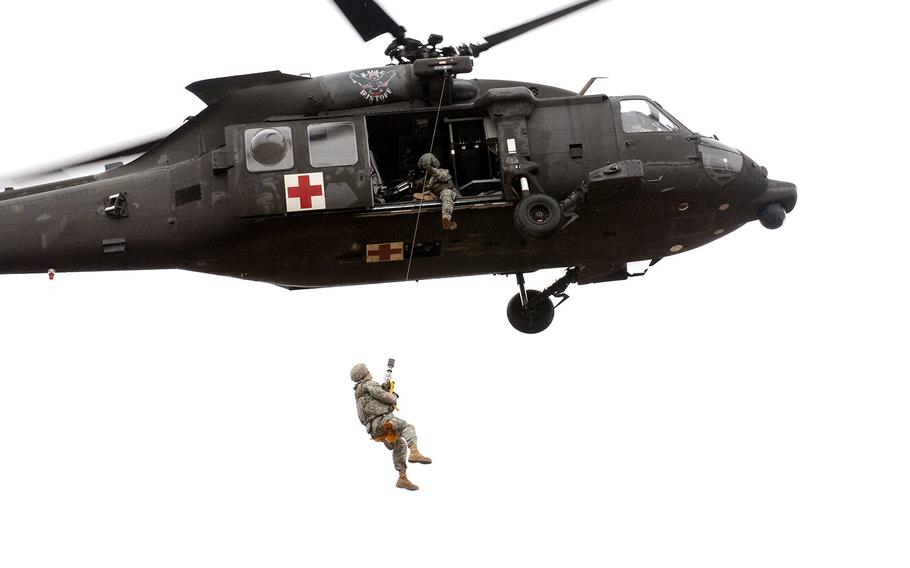 A medic with Company C, 101st Brigade Support Battalion, 1st Armored Brigade Combat Team, 1st Infantry Division, is hoisted up to a UH-60 Black Hawk helicopter during medical evacuation training March 8, 2016, at Fort Riley, Kan.