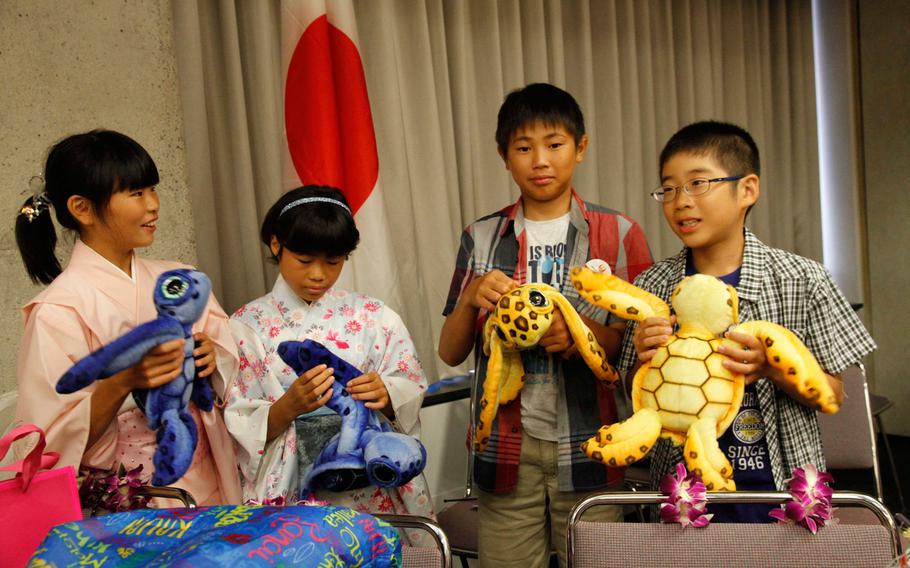 From left, Kumiko Yasui, Mihi Tazawa, Yosuke Yamaguchi and Kirito Uchikaneku hold gifts given to them at a reception at the Honolulu airport July 29, 2016. The four 11-year-olds live at the Holy Family Home orphanage in Osaka, Japan, and arrived to spend two weeks with families of the 27th Infantry Regiment.