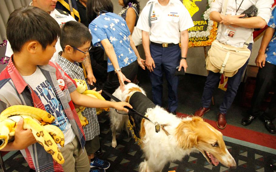 Yosuke Yamaguchi (left) and Kirito Uchikaneku pet the namesake mascot the 27th Infantry Regiment during a reception at the Honolulu airport July 29, 2016. 