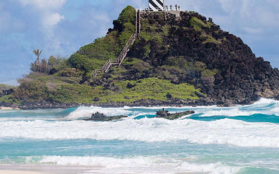 Two amphibious assault vehicles bob in the waves near Pyramid Rock during a drill for Rim of the Pacific July 30, 2016.