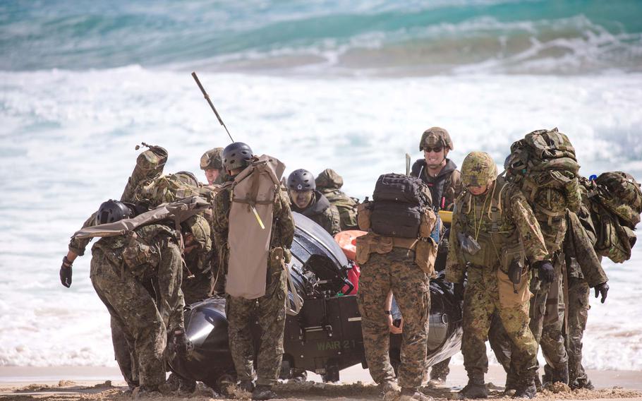 American and Japanese amphibious forces haul their watercraft onto the beach during the landing at Pyramid Rock Beach July 30, 2016.
                