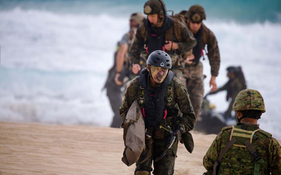 Members of the Japan Ground Self-Defense Force trudge ashore during the RIMPAC amphibious assault on Oahu July 30, 2016.
                