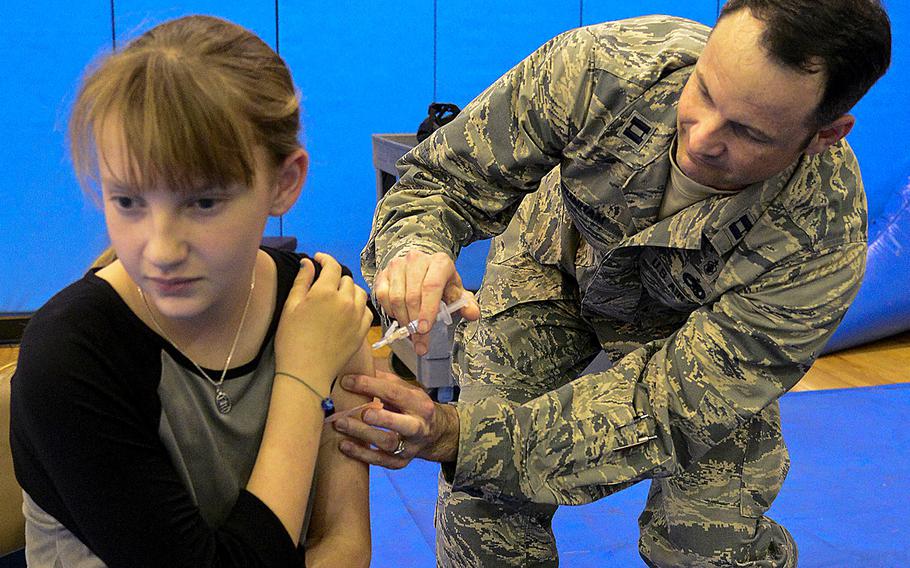 In an October, 2015 file photo, Capt. Marc Dunham of the 51st Medical Operations Squadron multi-service inpatient unit gives a child a flu shot at Osan Air Base, South Korea.