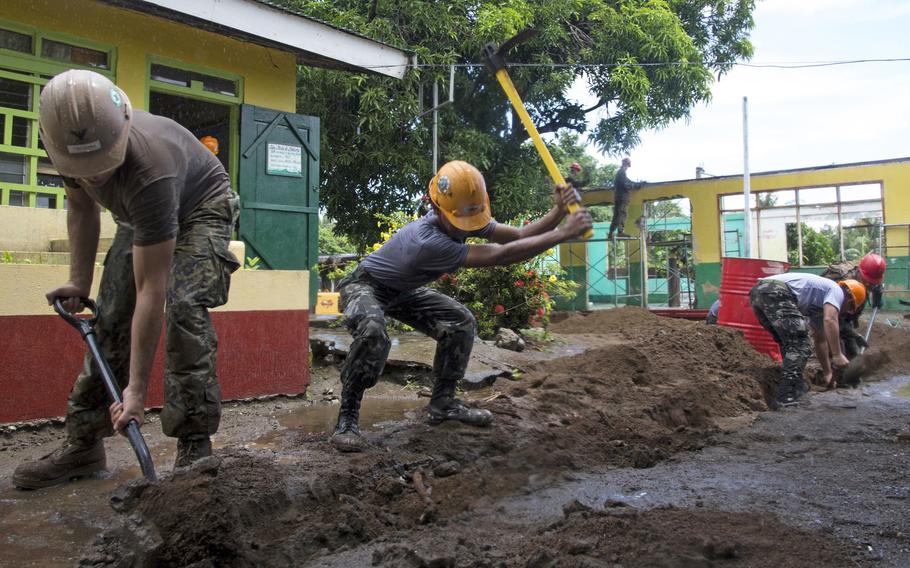 U.S. Marine Lance Cpl. Allen Tin, left, an engineer with 9th Engineer Support Battalion, 3rd Marine Logistics Group, and Navy Petty Officer 2nd Class Peter Tsicouris, second from left, a construction electrician with Naval Mobile Construction Battalion 5, work with Philippine navy builders to restore a section of the San Vicente Elementary School in Cagayan, Philippines, during a project for Philippine Amphibious Landing Exercise 33, Sept 24, 2016.