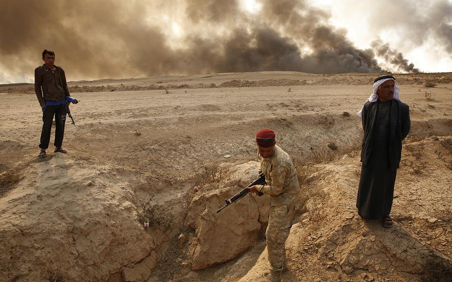 On the outskirts of the village of Al Hud, members of the Iraqi Army visit the area where locals say Islamic State executed four or five Peshmerga in recent months. Another grave containing many more people was in the area but too dangerous to visit due to mines.