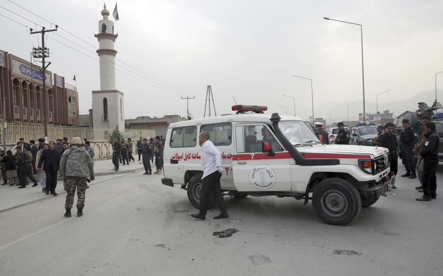 Afghan security forces, first responders and civilians walk around the Shiite Baqir-ul Ulom mosque after a suicide attack inside it, in Kabul, Afghanistan, Monday, Nov. 21, 2016. An Afghan official says that dozens of civilians have been killed after a suicide bomber attacked a Shiite mosque in the capital.