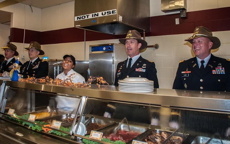 Leaders from the 11th Armored Cavalry Regiment take a moment to sing the 11th ACR song, Allons, between serving Thanksgiving meals to Fort Irwin Soldiers on Nov. 22, 2016 in California.