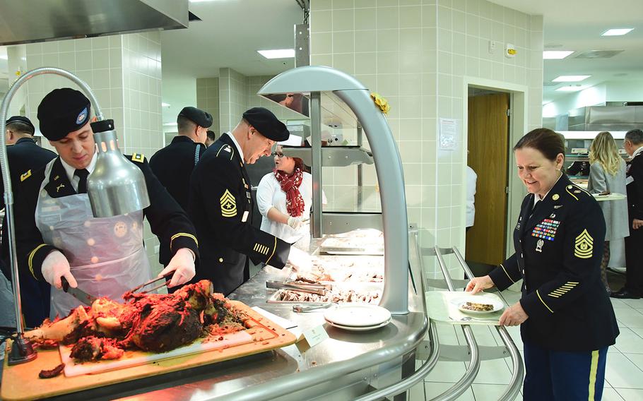 U.S. Army Europe Command Sgt. Maj. Sheryl Lyon, right, receives food on Nov. 22, 2016 during Thanksgiving celebrations at Caserma Del Din in Vicenza, Italy.