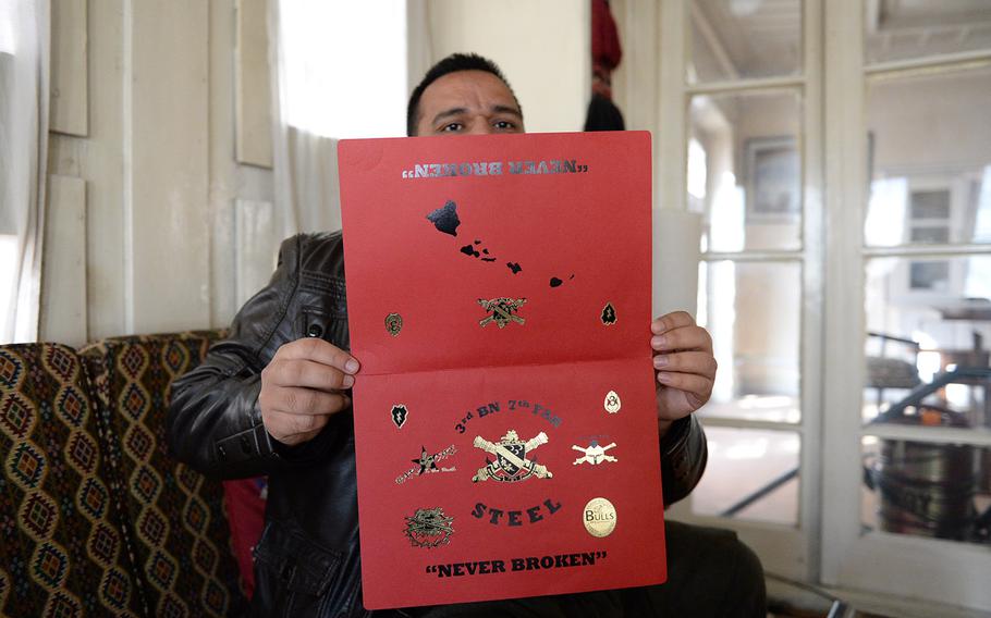 "Zakir," a former interpreter for the U.S. military in Afghanistan, fearing to show his face because of Taliban threats, hides behind an award he received.
