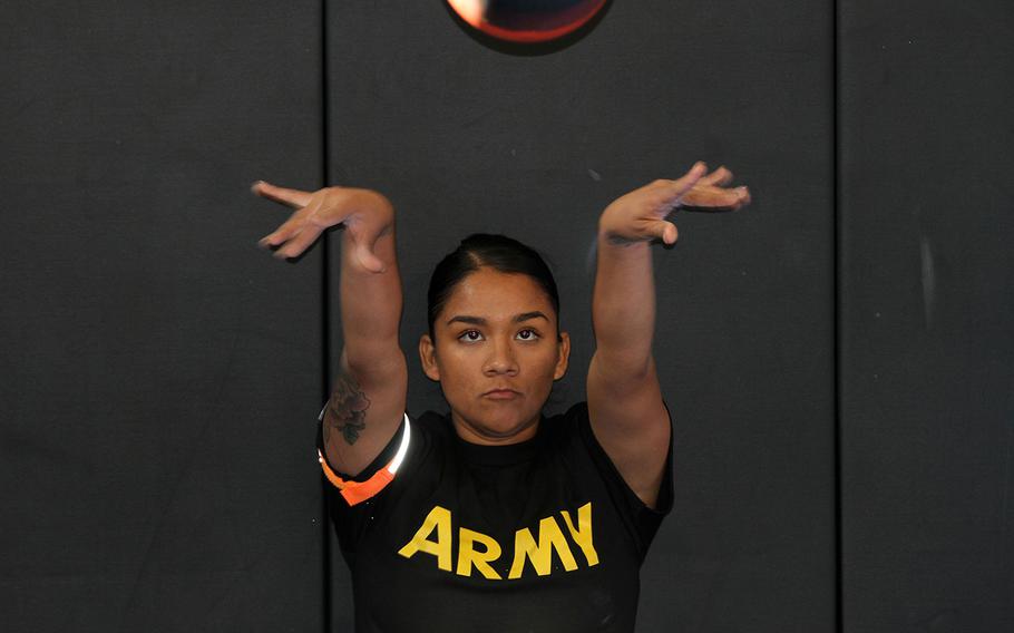Spc. Jazmin Garcia-Aguilar, 870th Military Police Company, 49th Military Police Brigade, tosses a medicine ball during the seated power throw of the Occupational Physical Assessment Test (OPAT) event Nov. 3, 2016 at Camp San Luis Obispo, California. 