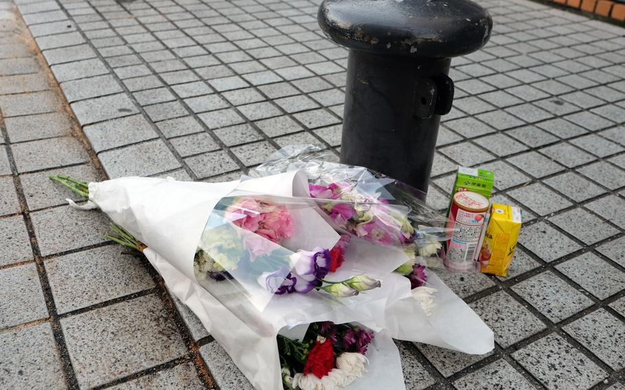 Flowers and snacks are left as a memorial at the site of a deadly crash that left three people dead and two children seriously injured. The crash occurred Saturday, Dec. 31, 2016 at a parking garage across the street from Yokosuka Naval Base. 