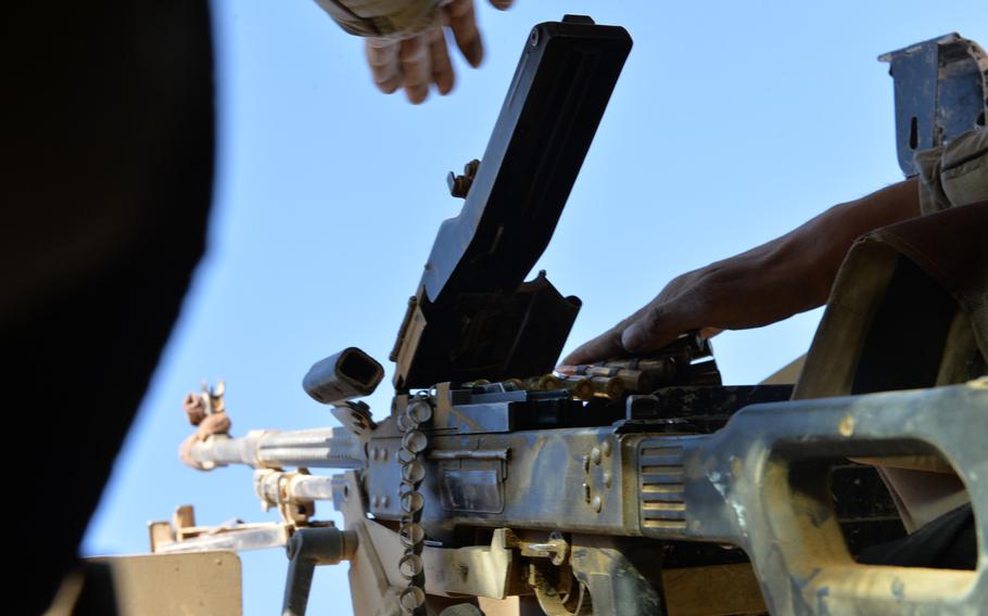 An Iraqi soldier loads a PK machine gun in the turret of an Iraqi army Humvee near Mosul, Nov. 19, 2016. Amnesty International found that Iraqi army weapons supplied by the U.S., Russia and other countries have wound up in the hands of Iran-backed Shiite militias accused of committing war crimes.
                