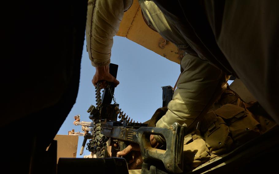 An Iraqi soldier loads a PK machine gun in the turret of an Iraqi army Humvee near Mosul on Nov. 19, 2016. 
                