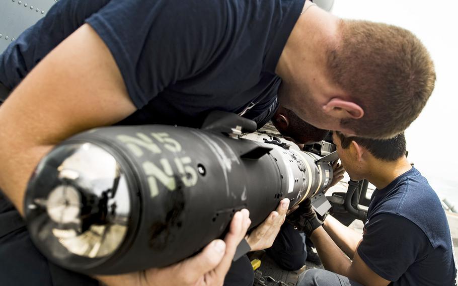 In a July, 2016 file photo, sailors load an AGM-114 Hellfire missile onto an MH-60R Seahawk Helicopter on the flight deck of the guided-missile cruiser San Jacinto in the Bab el Mandeb strait.