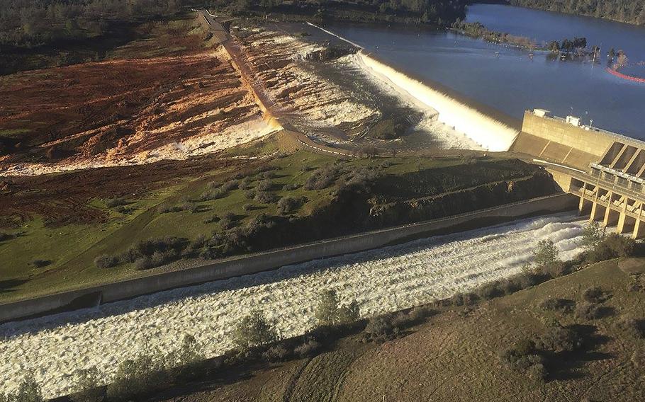 This Feb. 11, 2017, photo released by the California Department of Water Resources shows the main spillway, bottom, and an auxiliary spillway, upper, of the Oroville Dam at Lake Oroville in Oroville, Calif.