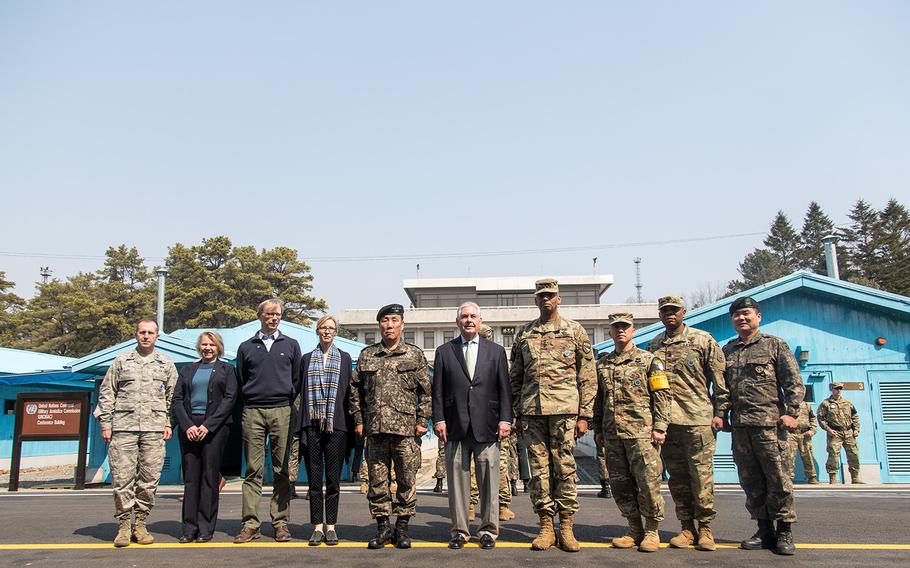 Secretary of State Rex Tillerson, center, stands in front of the armistice conferance buildings and North Korea at the Joint Security Area, March 17, 2017.