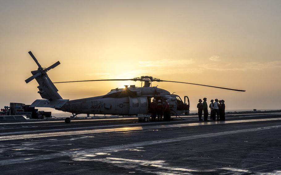 Flight deck crew onboard the aircraft carrier USS George H.W. Bush check a helicopter before take off in the Persian Gulf, April 20, 2017.
