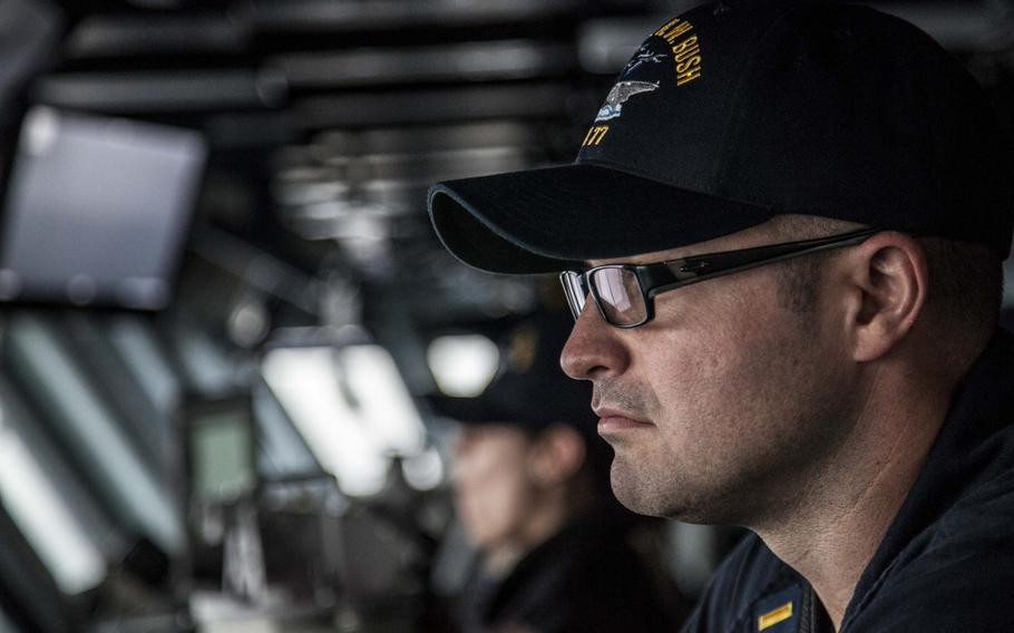An officer looks out over the flight deck of the aircraft carrier USS George H.W. Bush from the ship's bridge during flight operations in the Persian Gulf April 19, 2017.