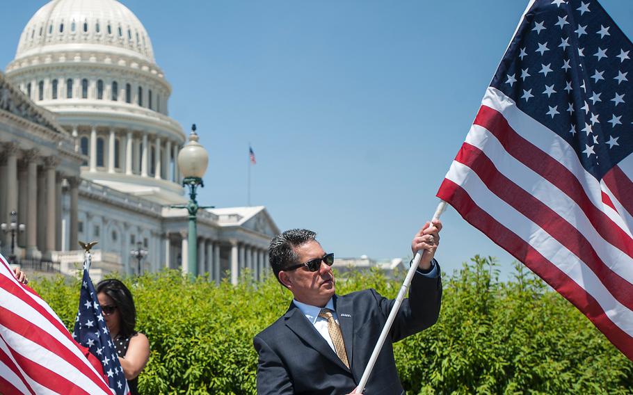Flags are unfurled during an event at the Capitol in Washington, D.C., on Wednesday, May 17, 2017. On Thursday, 35 veterans groups came together in Washington to reach some consensus on changes to the Post-9/11 GI Bill and restart their activity on Capitol Hill.