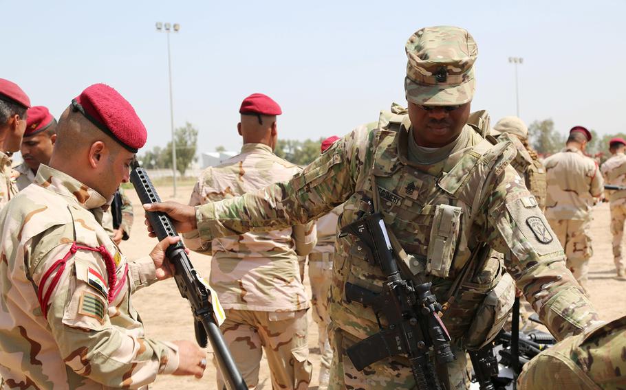 U.S. Army 1st Sgt. Gabriel Montgomery issues an M16 rifle to an Iraqi soldier during an Iraqi Train and Equip Fund issuing point at Camp Taji, Iraq, April 16, 2016. 