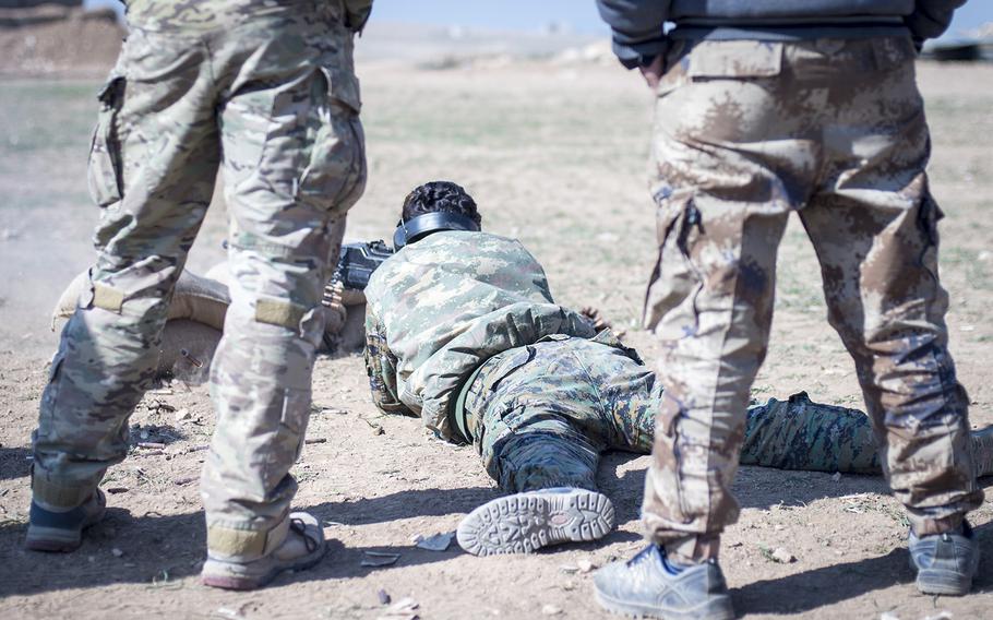 A U.S. special forces operator advises a female Manbij Military Council trainee during marksmanship training Feb. 21, 2017, at Sanaa Training Center in Northwest Syria.