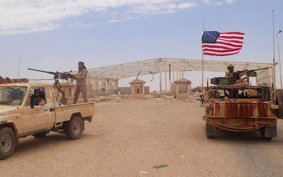 In this photo taken on Tuesday May 23, 2017, provided by the Syrian anti-government activist group, the Hammurabi's Justice News, which has been authenticated based on its contents and other AP reporting, shows a U.S.-backed anti-government Syrian fighter from Maghaweer al-Thawra standing on a vehicle with heavy automatic machine gun, left, as an American soldier also stands on his armored vehicle as they take their position at the Syrian-Iraqi crossing border point of Tanf, south Syria.