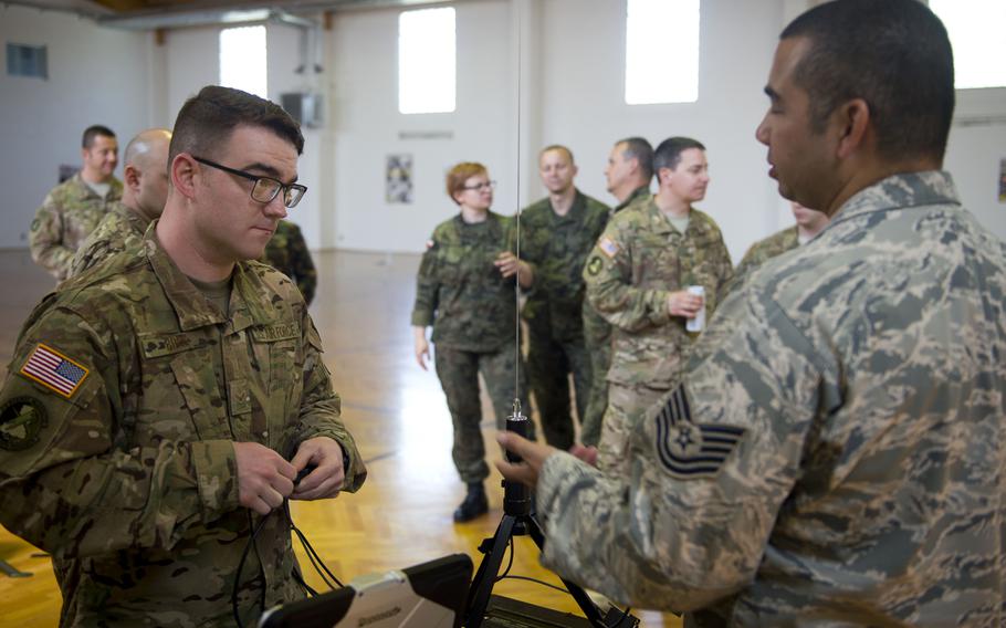 U.S. Air Force Airman 1st Class Andrew Boos, left, listens to Tech. Sgt. Christopher Hardy give instructions on configuring a Tactical Meteorological Observing System radio transmitter during Exercise Cadre Focus 17-1 at McCully Barracks, Germany, on Wednesday, June 14, 2017. Boos and Hardy are both from the 7th Weather Squadron. 
                