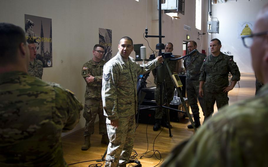 Tech. Sgt. Christopher Hardy, from the 7th Weather Squadron, describes how to configure a Tactical Meteorological Observing System radio transmitter during Exercise Cadre Focus 17-1 at McCully Barracks, Germany, on Wednesday, June 14, 2017. 