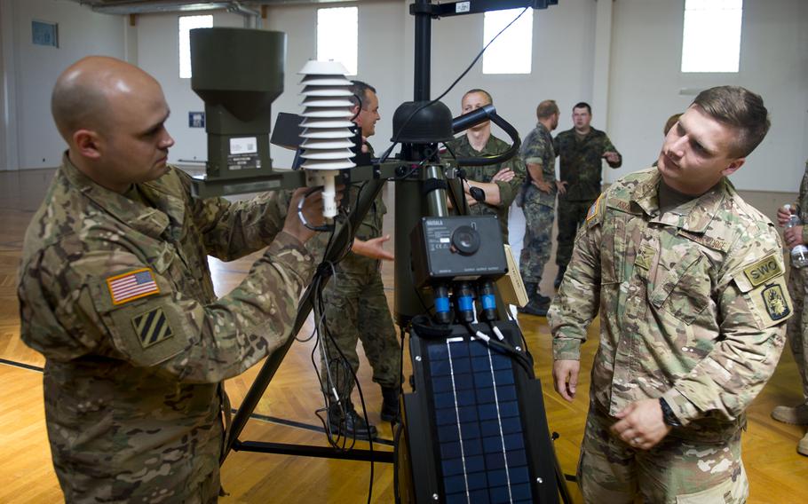 U.S. Air Force Airman 1st Class Athon Arant, right, observes Master Sgt. Steven Hollatz connecting a radio modem to a Tactical Meteorological Observing System during Exercise Cadre Focus 17-1 at McCully Barracks, Germany, on Wednesday, June 14, 2017. 
                