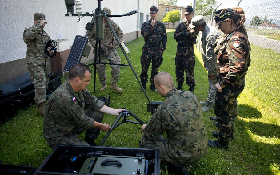 U.S. airmen, Polish soldiers and Hungarian soldiers assemble a Tactical Meteorological Observing System during Exercise Cadre Focus 17-1 at McCully Barracks, Germany, on Wednesday, June 14, 2017. 
                