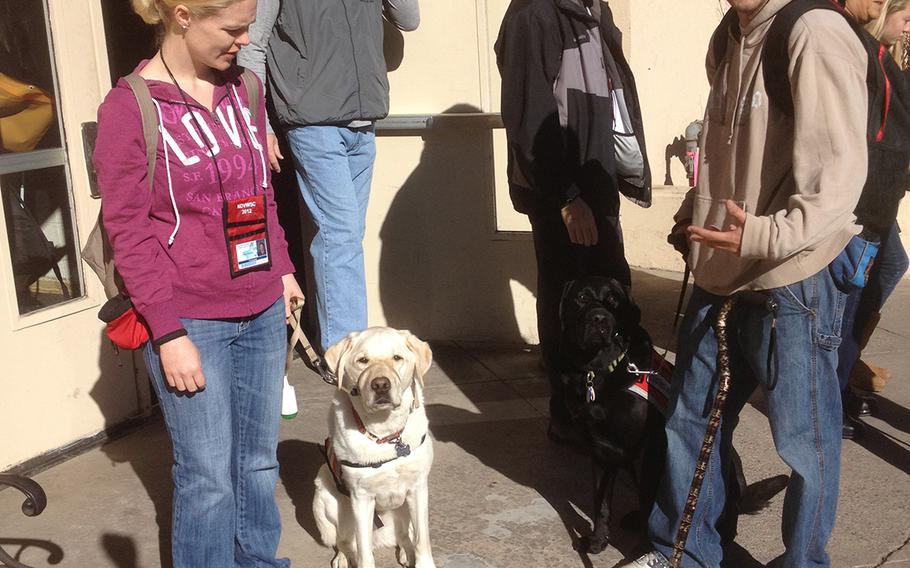 In an undated file photo, Alexis Courneen and her service dog, Sooner, pause outside a veterans event
