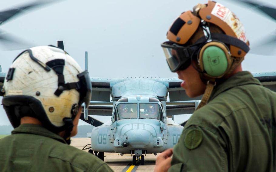 Marine Cpl. Brandon Guico, a Marine Medium Tiltrotor Squadron 262 airframe aerial observer, and William Payne, a VMM-262 avionics technician, watch an MV-22 Osprey take off at Misawa Air Base, Japan, July 31, 2017.