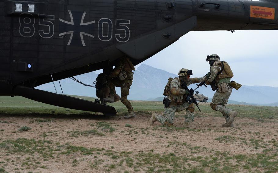 A Georgian soldier provides cover as members of Train, Advise and Assist Command-North's Quick Reaction Force climb aboard a German helicopter in 2015.