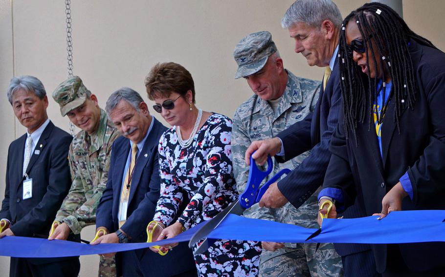 Thomas Brady, director of Department of Defense Education Activity, cuts a ceremonial ribbon for the new Yokota High School building at Yokota Air Base, Japan, Monday, Sept. 25, 2017. Flanking him are Col. Kenneth Moss, 374th Airlift Wing commander, and principal Priscilla Hill.